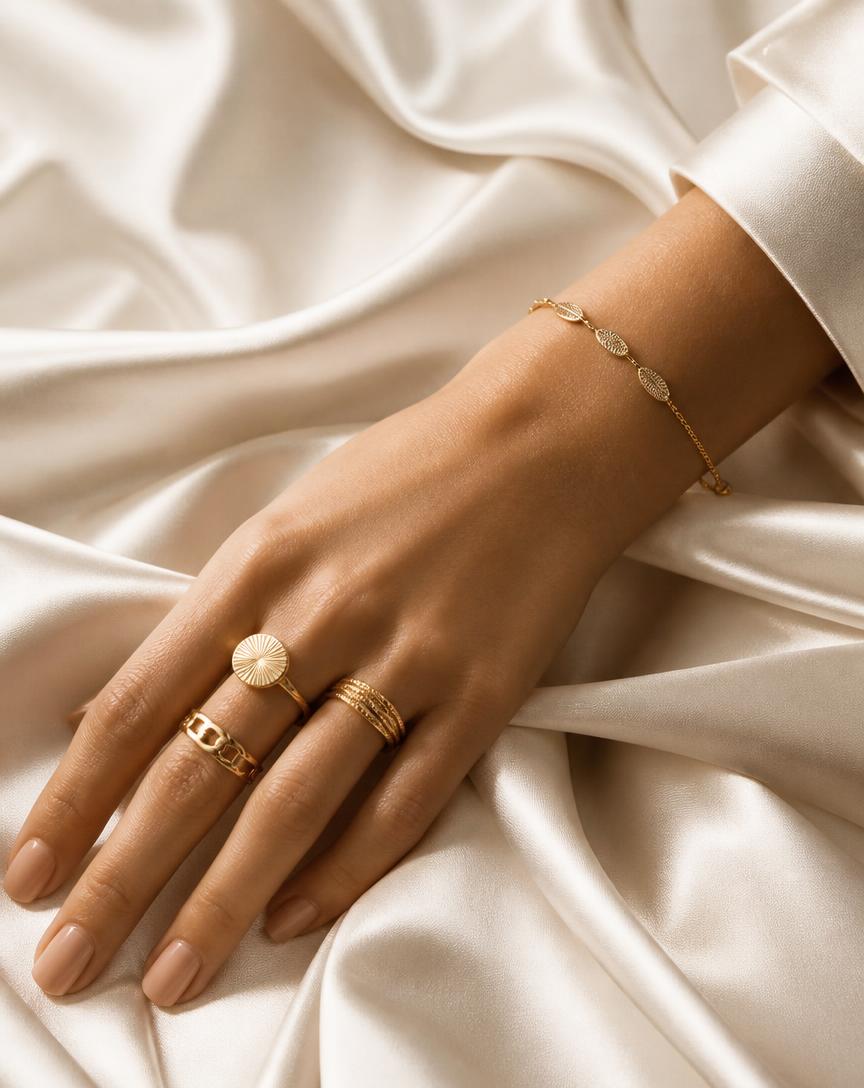 Anéis e bracelete dourados sobre seda